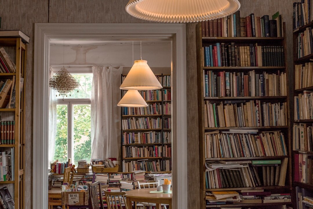 Cozy old library interior with tall bookshelves and warm lamp light